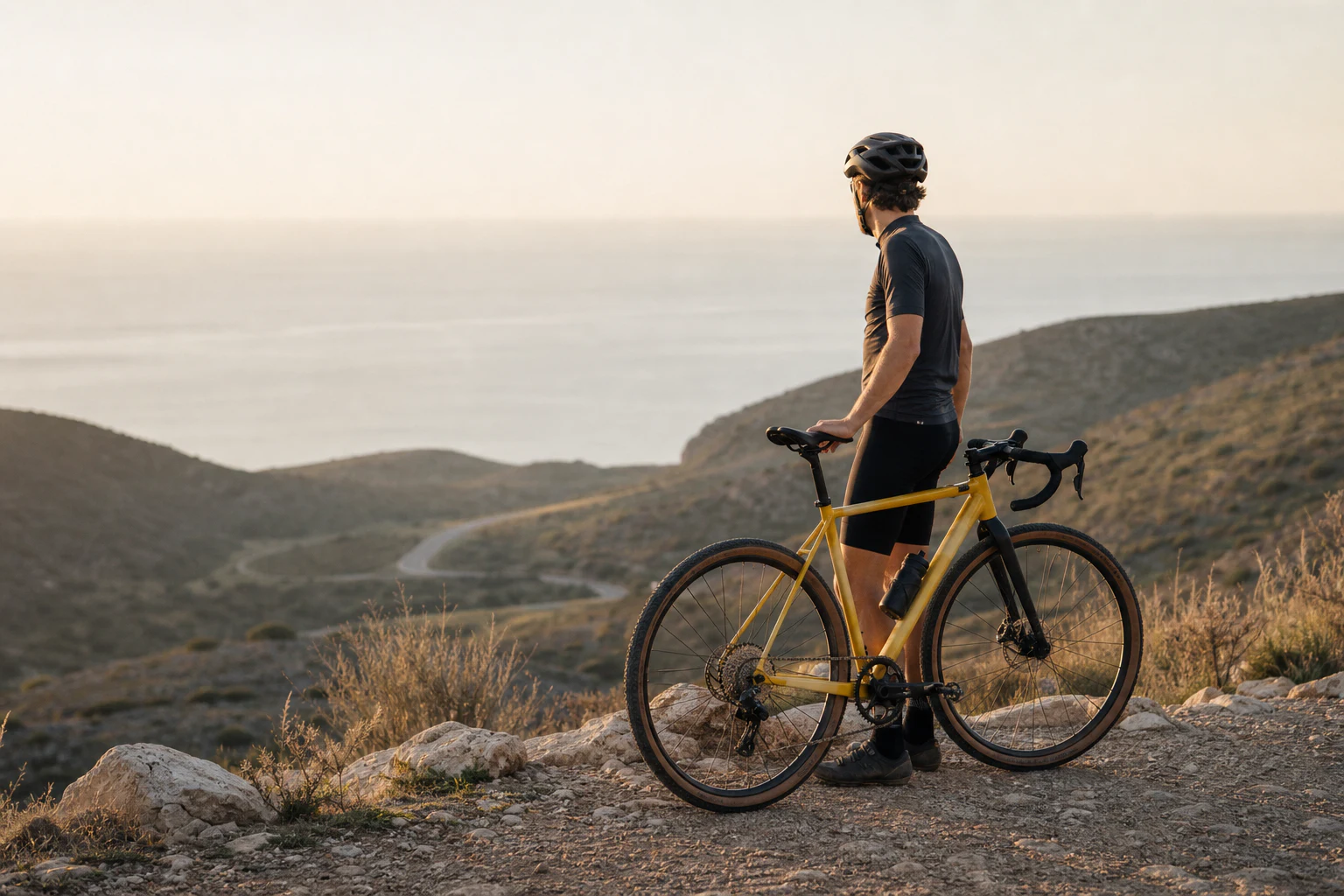 Rider with a yellow gravel bike at a quiet coastal overlook after a ride